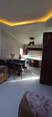 a living room with a table and a dining room at ام القطين لونج in Umm al Qiţţayn