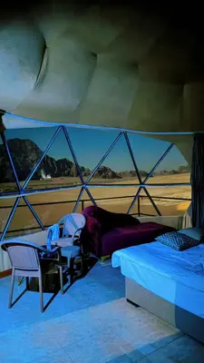 a bedroom with a bed and a table and chairs at Eram camp in Jurf ad Darāwīsh