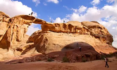 a group of people standing on top of a rock formation at Eram camp in Jurf ad Darāwīsh