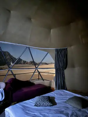 a bedroom with a bed and a view of the desert at Eram camp in Jurf ad Darāwīsh