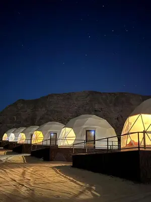 a row of domes in the desert at night at Eram camp in Jurf ad Darāwīsh