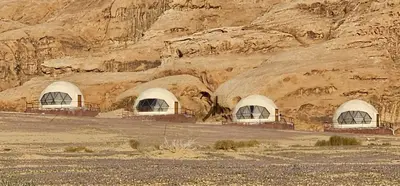 a group of domes in front of a rocky mountain at Eram camp in Jurf ad Darāwīsh