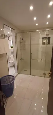 a bathroom with a shower and a glass door at LV luxury apartment Deir Ghbar in Amman
