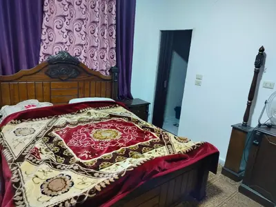 a bedroom with a bed with a red and yellow blanket at شقق ابو يزن عجلون بالقرب من محمية عجلون in Ajloun