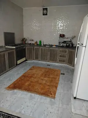 a kitchen with a rug on the floor and a refrigerator at شقق ابو يزن عجلون بالقرب من محمية عجلون in Ajloun
