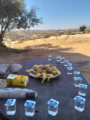 a table with glasses of water and fruit on it at Dana Village experience hotel in Dana