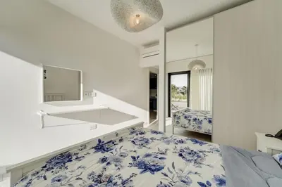a bedroom with a blue and white bed and a mirror at Emerald Beach Apartment in Aqaba