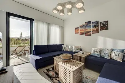 a living room with a blue couch and a table at Emerald Beach Apartment in Aqaba
