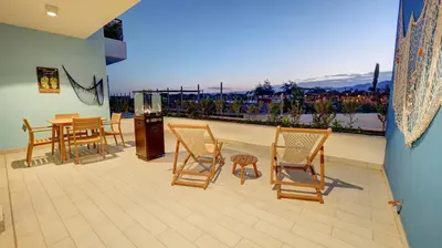 a room with chairs and a table and a balcony at Emerald Beach Apartment in Aqaba