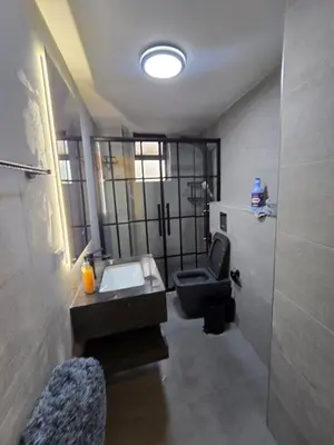 a bathroom with a sink and a chair in it at Rainbow Retreat - 2BR in the heart of Old Amman in Amman