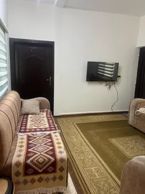 a living room with a couch and a television at Altamem apartment in Um Qeis