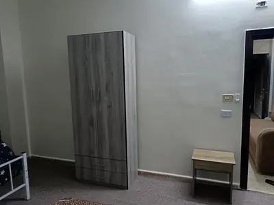 a wooden cabinet in the corner of a room at Altamem apartment in Um Qeis
