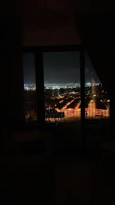 a view of a city at night from a window at Ayla Beach Apartment Azure 1522 Families only in Aqaba