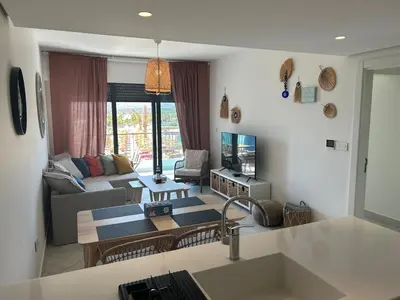 a living room with a couch and a table at Ayla Beach Apartment Azure 1522 Families only in Aqaba