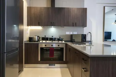 a kitchen with wooden cabinets and a stove top oven at Boulevard luxury Studio in Amman