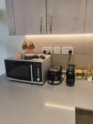a kitchen counter with a microwave and a toaster at Boulevard luxury Studio in Amman