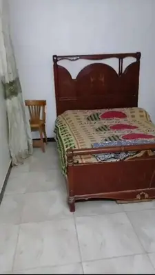 a bed sitting in a room with a tiled floor at الثغره هاوس in Abū al Lasan