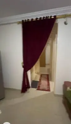 a hallway with a red curtain in a building at الثغره هاوس in Abū al Lasan
