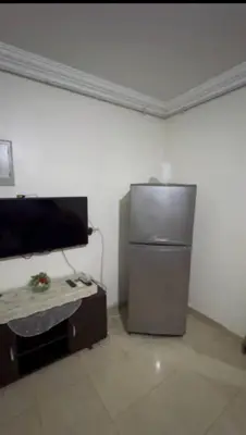 a room with a refrigerator and a table in it at الثغره هاوس in Abū al Lasan