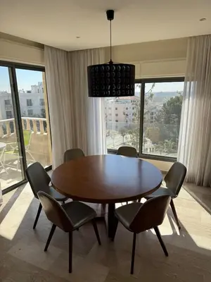 a dining room with a wooden table and chairs at The Olive- Bright, Spacious&Newly Renovated in Amman
