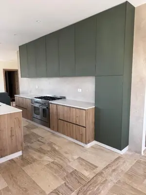 a kitchen with green cabinets and a stove at The Olive- Bright, Spacious&Newly Renovated in Amman