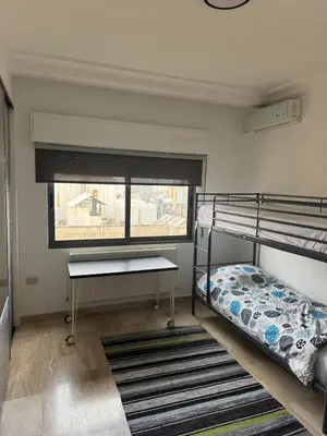 a bedroom with two bunk beds and a window at The Olive- Bright, Spacious&Newly Renovated in Amman