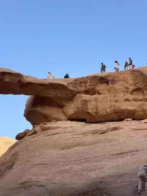 a group of people standing on top of a rock at My X wadirum in Wadi Rum
