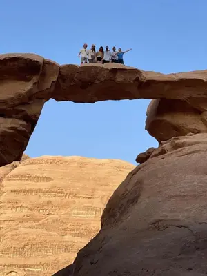 a group of people standing on top of a rock formation at My X wadirum in Wadi Rum