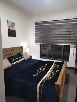 a bedroom with a large bed and a window at عمان in Jurf ad Darāwīsh