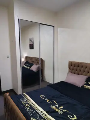 a bedroom with a bed with a large mirror at عمان in Jurf ad Darāwīsh