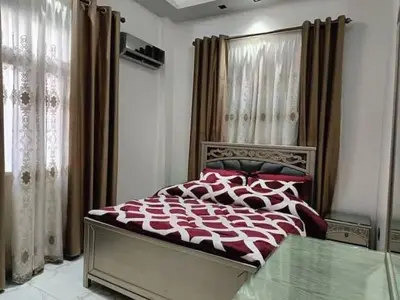 a bedroom with a bed with a red and white comforter at جرف العز هاوس in Jurf ad Darāwīsh