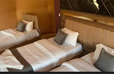 two beds in a room with white sheets and pillows at Star Wars luxury camp in Wadi Rum
