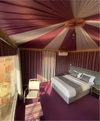 a bedroom with a bed with a purple ceiling at Star Wars luxury camp in Wadi Rum