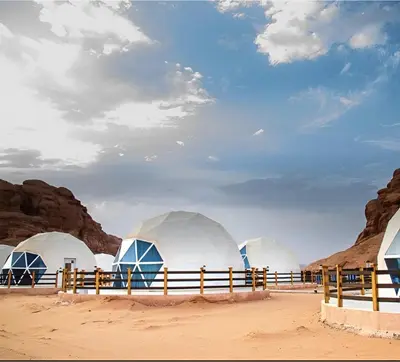a group of domes on the beach with rocks at Star Wars luxury camp in Wadi Rum