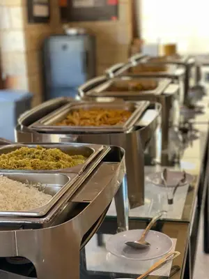 a row of trays of food in a cafeteria at Bedouin Luxury Camp in Wadi Rum