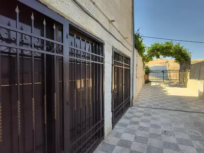 a building with black doors on the side of it at Shafa Badran Studio in Jurf ad Darāwīsh