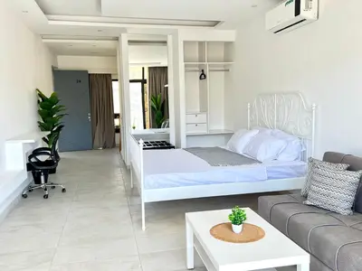 a white bedroom with a bed and a couch at Brand new, Modern, Breathtaking view, just for you in Amman
