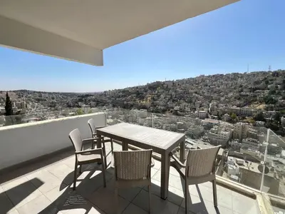 a table and chairs on a balcony with a view at Brand new, Modern, Breathtaking view, just for you in Amman