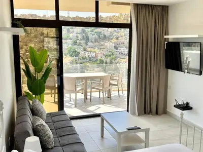 a living room with a couch and a table at Brand new, Modern, Breathtaking view, just for you in Amman