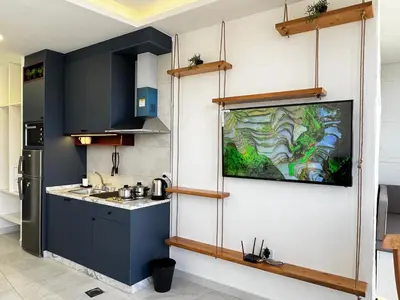 a kitchen with blue cabinets and a painting on the wall at Brand new, Modern, Breathtaking view, just for you in Amman