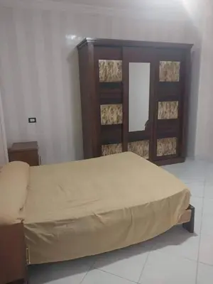 a bedroom with a large bed with a wooden headboard at ابيت السعاده in Ar Ramthā