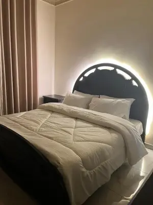 a bedroom with a large white bed with an arch overhead at Family-Friendly Garden Stay in Jurf ad Darāwīsh