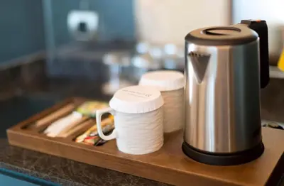 a coffee maker sitting on a wooden tray on a counter at Radisson Wadi Rum Luxury Camp in Wadi Rum
