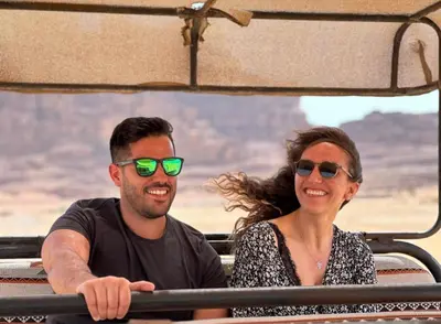 a man and woman sitting in a jeep in the grand canyon at Radisson Wadi Rum Luxury Camp in Wadi Rum