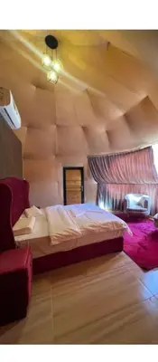 a bedroom with a large bed with a wooden ceiling at Wadi rum ail camp in Wadi Rum