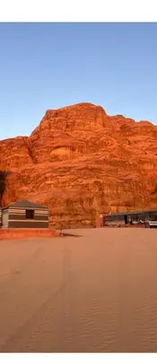 a building in front of a red mountain at Wadi rum ail camp in Wadi Rum