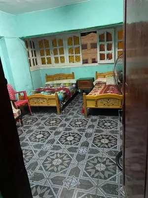 a room with two beds and a tiled floor at مخيم الخال in Yarqā