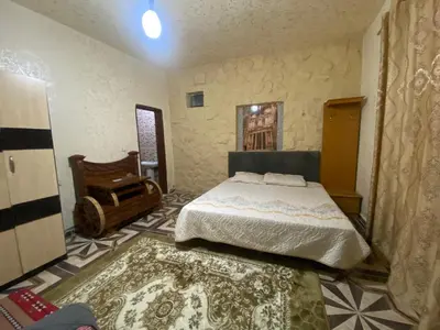 a bedroom with a bed and a chair and a rug at Mohmad House in Jurf ad Darāwīsh