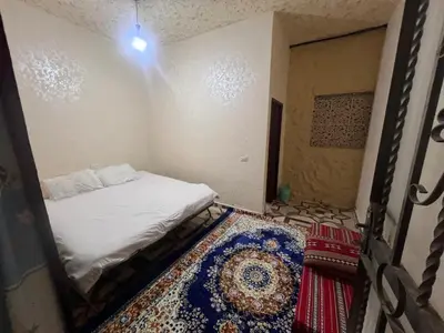 a small room with a bed and a rug at Mohmad House in Jurf ad Darāwīsh