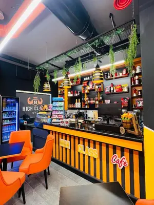 a fast food restaurant with orange chairs and a counter at فندق الأمراء بلازا in Ma‘ān
